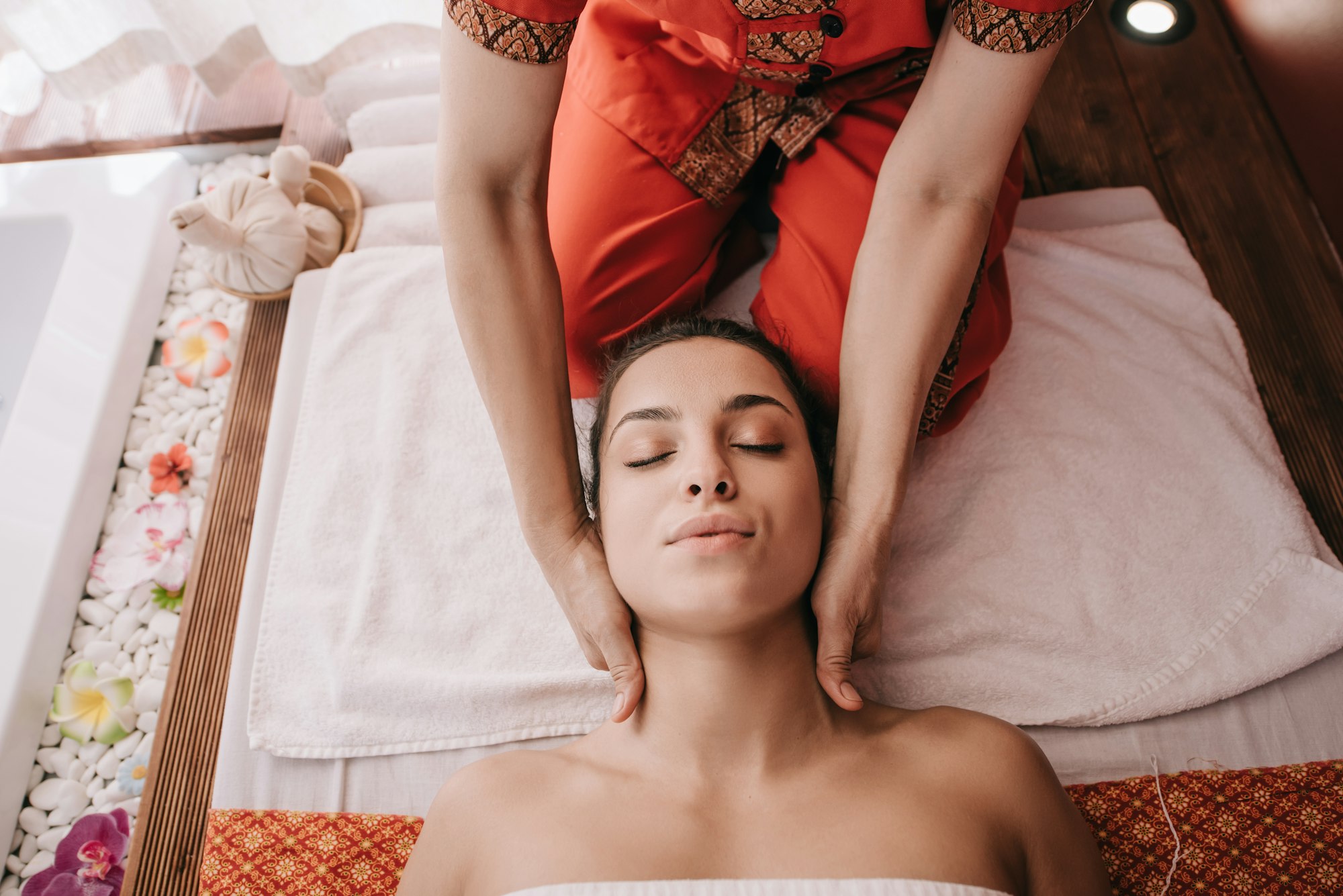 cropped view of masseur doing neck massage to woman in spa salon